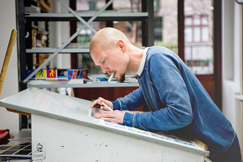 Ung mand står og arbejder