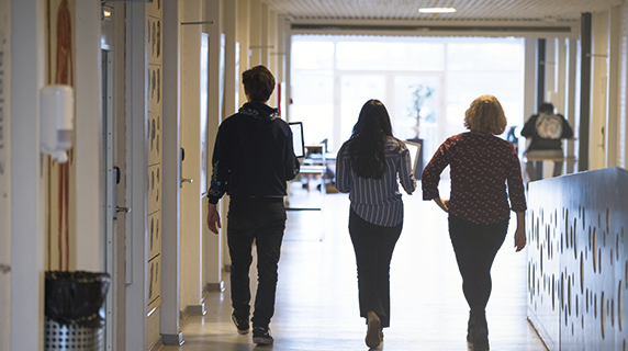 Tre elever går på en gymnasiegang